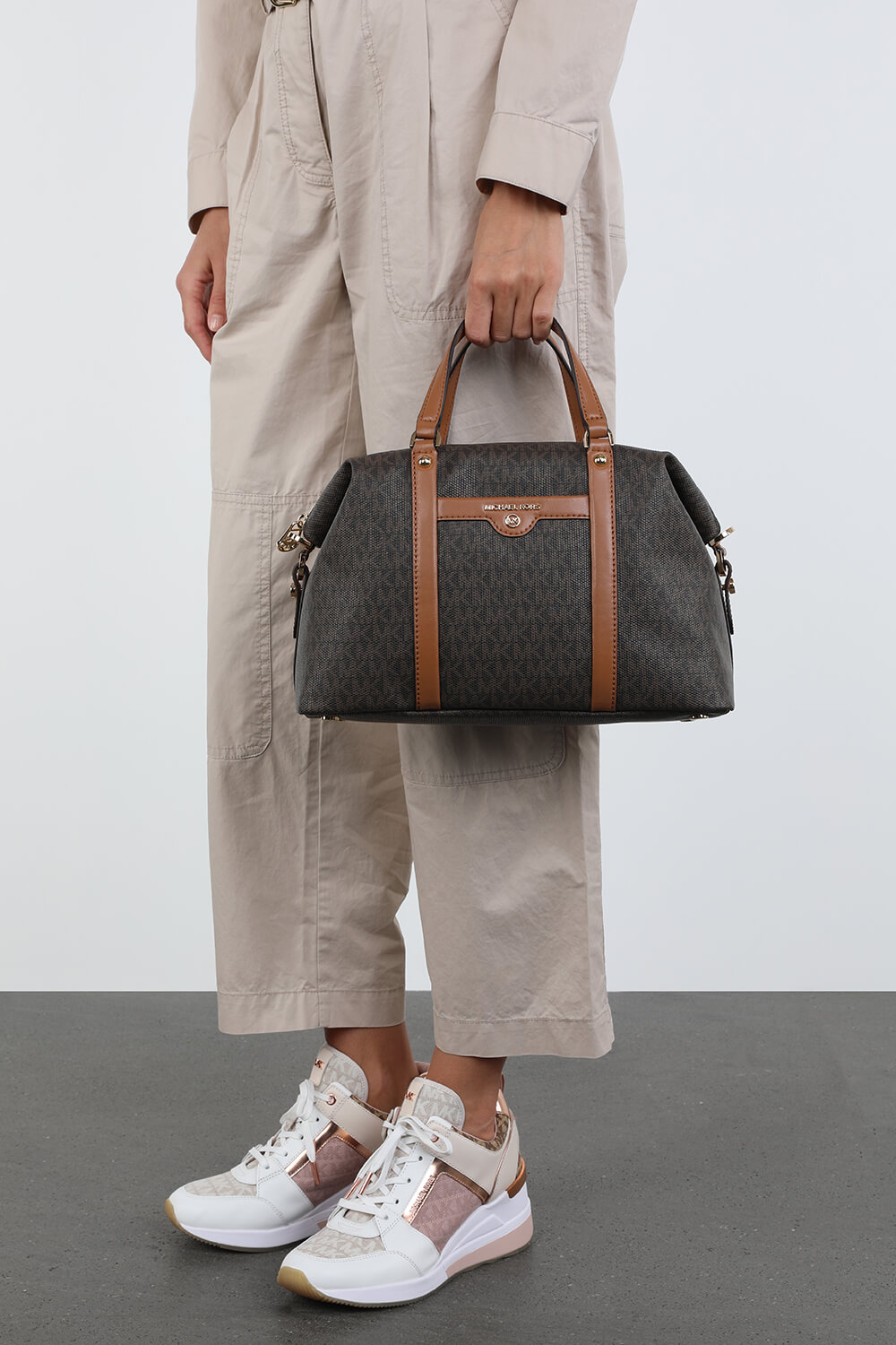 תמונת כל הלוק של תיק נשיאה חום עם לוגו מטאלי